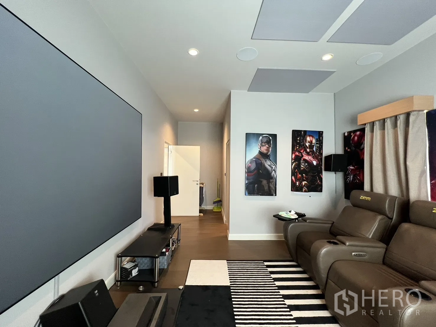 Detached House for rent or sale in Mueang Pathum Thani, Pathum Thani - Home theater with three recliners facing a large screen wall.