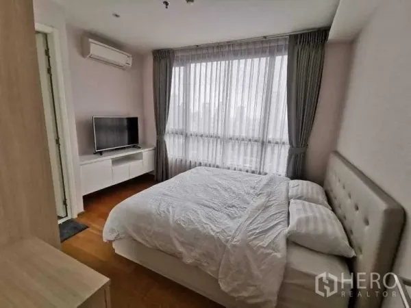 公寓 出租或出售在Phra Khanong, Bangkok - 主卧配大窗与纱帘、电视柜及空调。