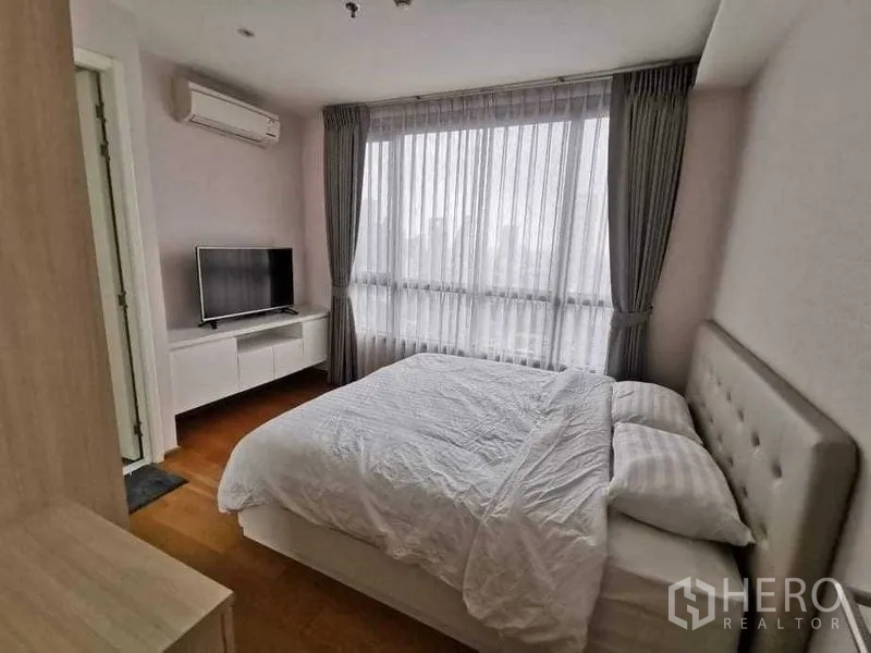 公寓 出租或出售在Phra Khanong, Bangkok - 主卧配大窗与纱帘、电视柜及空调。