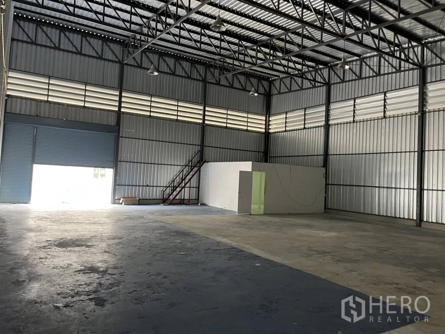 โกดัง for rent in Bang Phli, Samut Prakan - พื้นที่เก็บสินค้าโล่ง เห็นยูนิตออฟฟิศภายในและบันไดข้างประตูม้วน