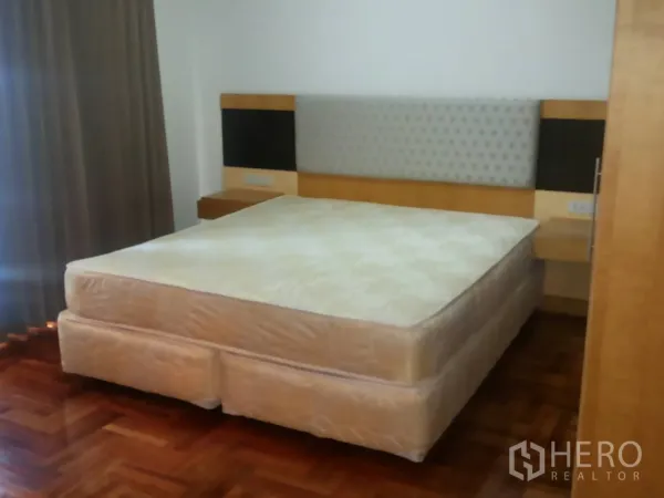 อพาร์ทเมนท์ ให้เช่าในKhlong Toei, Bangkok - ห้องนอนอีกห้องพร้อมเฮดบอร์ดบุผ้า ชั้นข้างเตียง และพื้นปาร์เกต์