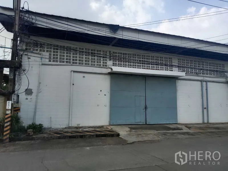 工厂 出租在Samut Prakan - 临街立面，巨型钢门、坡道与通风砌块墙