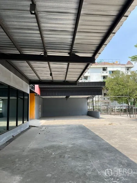 零售空间 出租在Saphan Sung, Bangkok - 玻璃店面外长遮雨棚，前方宽阔混凝土停放区。