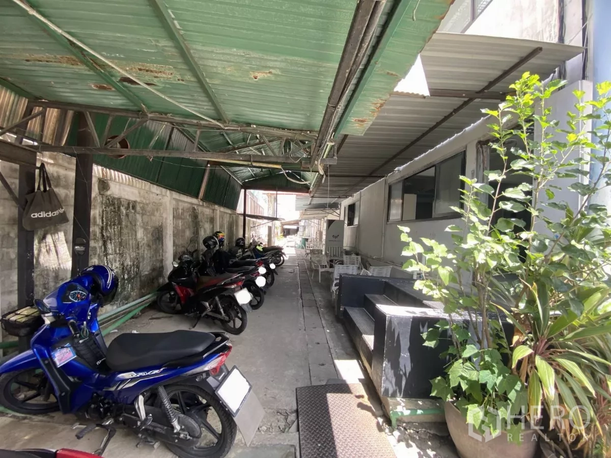 Factory for sale in Khlong Toei, Bangkok - Covered motorcycle parking along the side walkway of the building