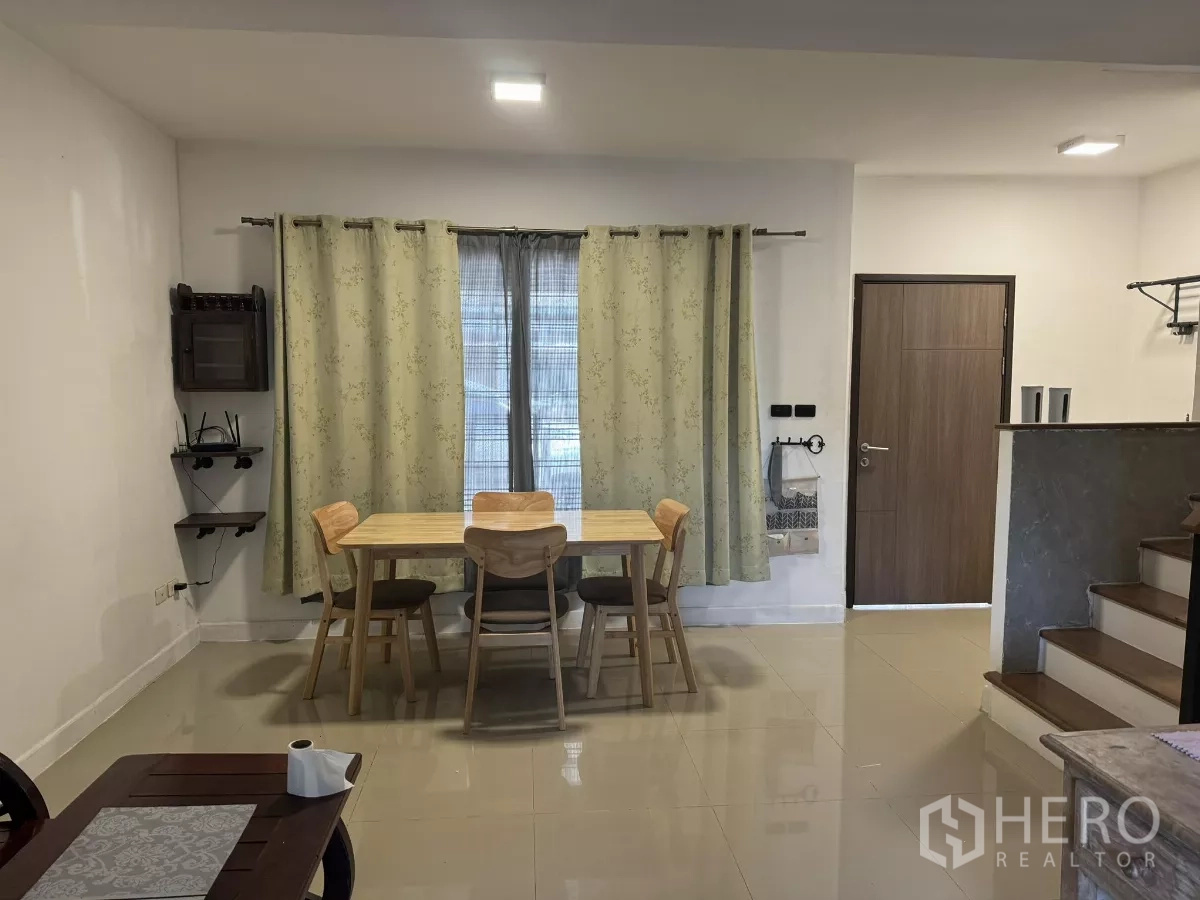 ทาวน์เฮาส์ ให้เช่าในSuan Luang, Bangkok - มุมรับประทานอาหารสว่าง โต๊ะไม้ 4 ที่นั่ง ม่านหน้าต่าง และพื้นกระเบื้องใกล้ประตูเข้าออก