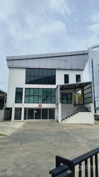 Office Space for rent in Khlong Toei, Bangkok - Modern three-storey office building with large windows and a wide driveway.