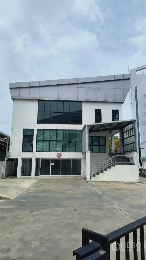 Office Space for rent in Khlong Toei, Bangkok - Modern three-storey office building with large windows and a wide driveway.
