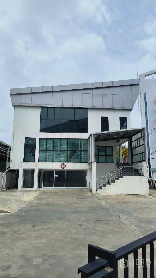 Office Space for rent in Khlong Toei, Bangkok - Modern three-storey office building with large windows and a wide driveway.