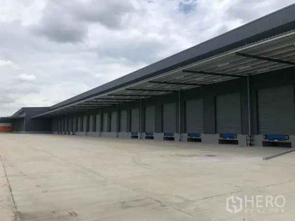 工厂 出租在Wang Noi, Phra Nakhon Si Ayutthaya - 带雨棚的长条装卸月台，多个卷闸门与宽阔卡车作业区