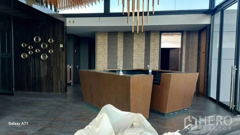 สำนักงานที่บ้าน ให้เช่าในNong Khaem, Bangkok - เลาจน์ดาดฟ้าพร้อมเคาน์เตอร์บาร์ไม้ ฝ้าเพดานดีไซน์ และผนังกระจกเต็มบาน