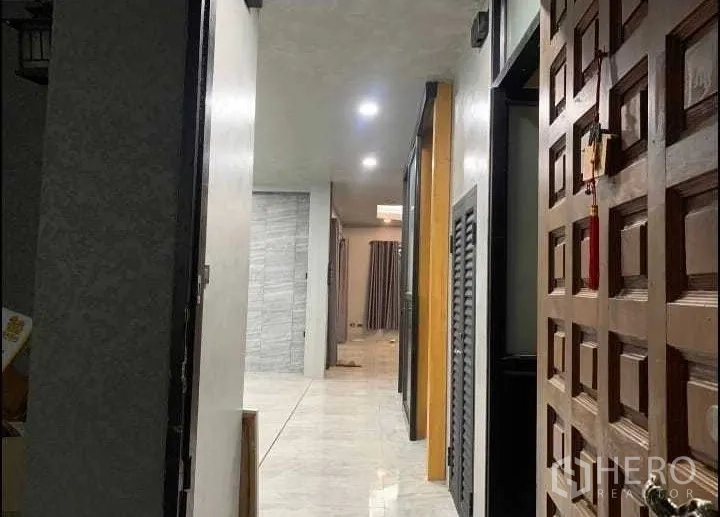 Detached House for rent or sale in Wang Thonglang, Bangkok - Entrance hallway with wooden front door, downlights and glossy tile flooring.