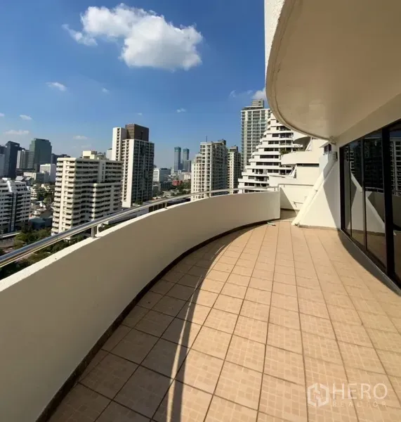 公寓 出租或出售在Watthana, Bangkok - 宽大的弧形阳台，瓷砖地面，眺望城市天际线。