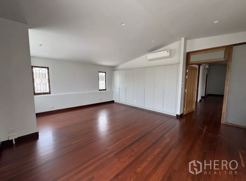 独立式住宅 出租在Watthana, Bangkok - 卧室内置白色衣柜、空调与木地板。