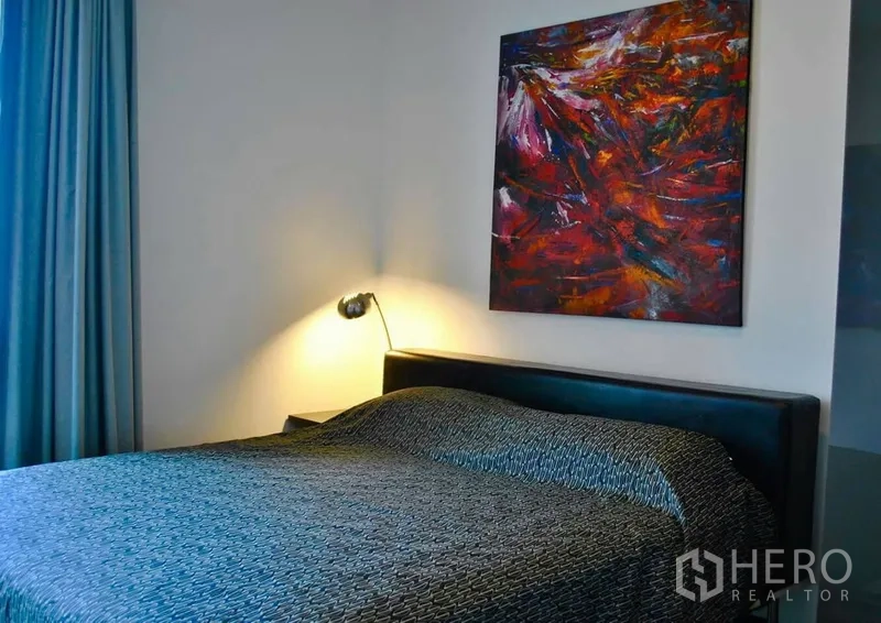 คอนโด ให้เช่าในWatthana, Bangkok - ห้องนอนที่สองอบอุ่น มีงานศิลปะบนผนัง โคมไฟหัวเตียง และผ้าม่านทึบ