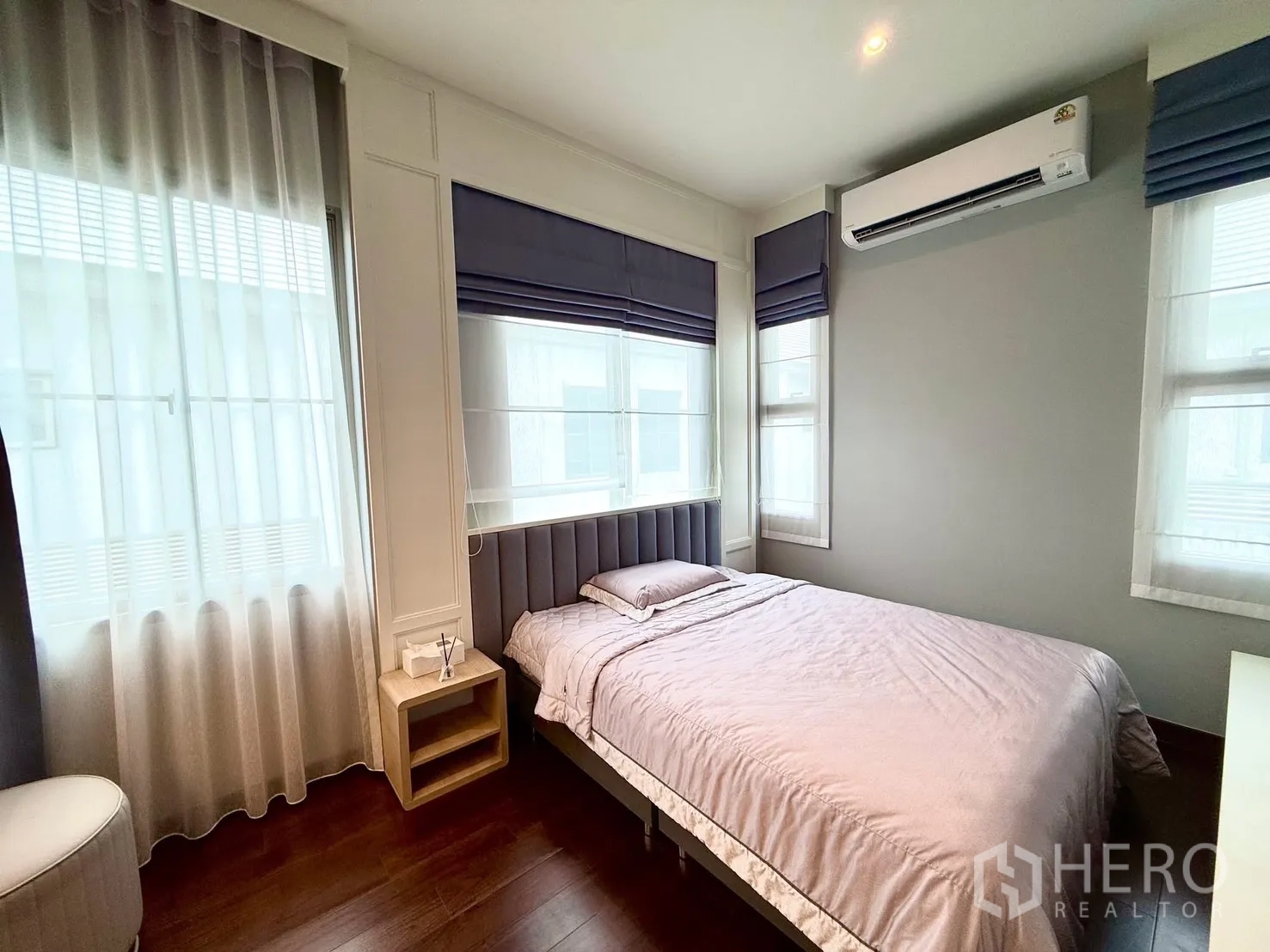 Detached House for rent or sale in Bang Phli, Samut Prakan - Cozy bedroom with double bed, AC unit, corner windows and soft grey decor.
