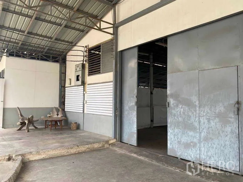 Warehouse for rent in Bang Sue, Bangkok - Wide sliding metal doors and covered loading bay at the warehouse entrance.