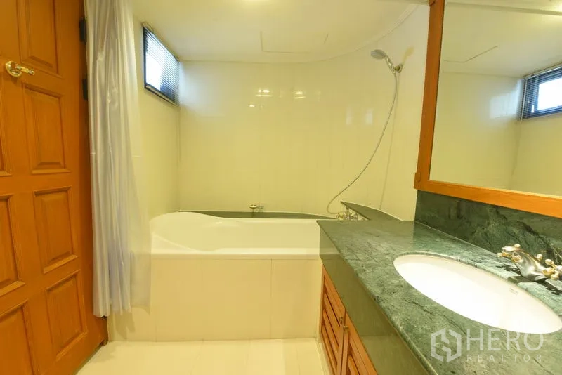 อพาร์ทเมนท์ ให้เช่าในWatthana, Bangkok - ห้องน้ำพร้อมอ่างอาบน้ำ-ฝักบัว กระจกบานใหญ่ และเคาน์เตอร์หินอ่อนสีเขียว