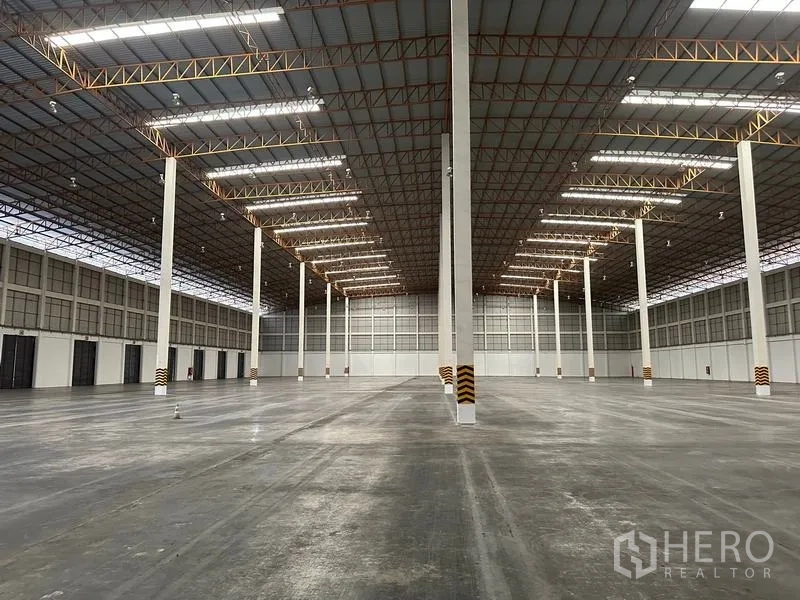 คลังสินค้า ให้เช่าในPhra Nakhon Si Ayutthaya - มุมมองสมมาตรตามแนวช่องทางในโกดัง หลังคาติดแผ่นแสงสว่าง