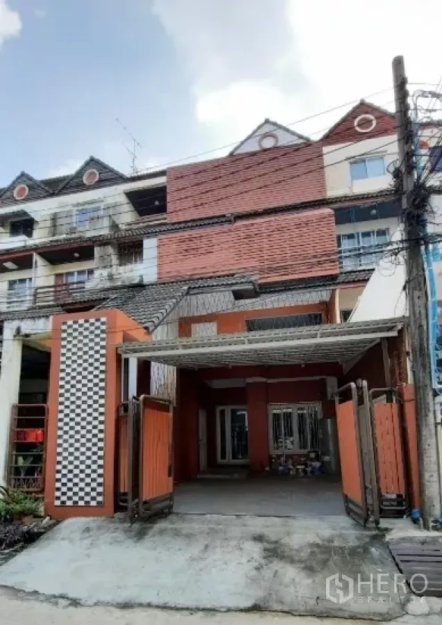 Townhouse for sale in Suan Luang, Bangkok - Four-storey townhouse facade with gated carport on a quiet lane