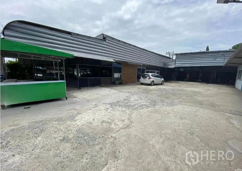 货栈 出租在Mueang Nonthaburi, Nonthaburi - 仓库外观与宽阔混凝土地坪，设有雨棚装卸区和停车位。