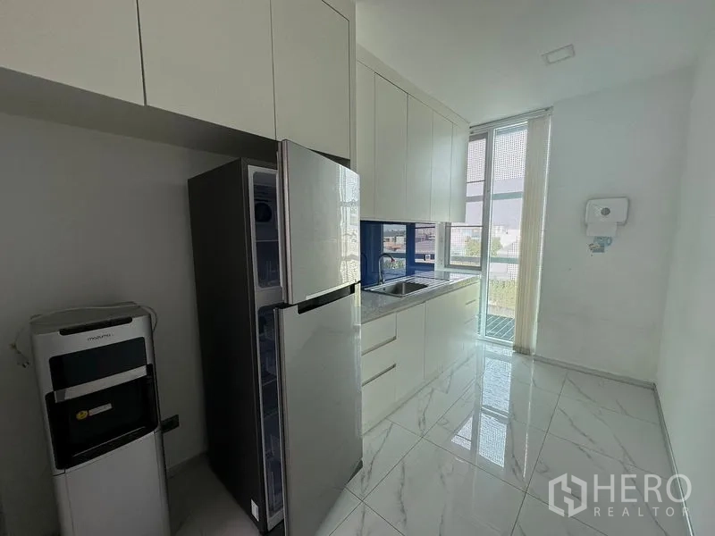 Office Space for rent - Pantry with white cabinetry, sink, refrigerator, and floor-to-ceiling window.