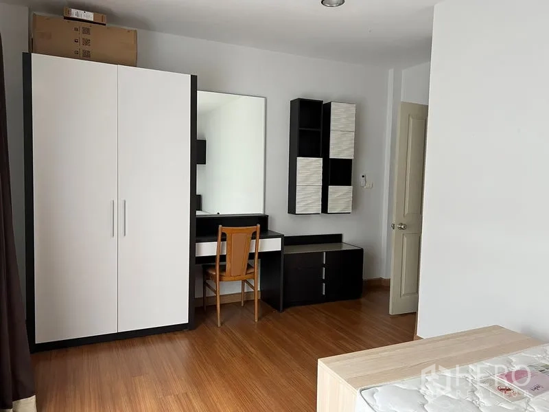 ทาวน์เฮาส์ ให้เช่าในSaphan Sung, Bangkok - มุมห้องนอนพร้อมตู้เสื้อผ้า โต๊ะเครื่องแป้ง และชั้นเก็บของโทนขาวดำ