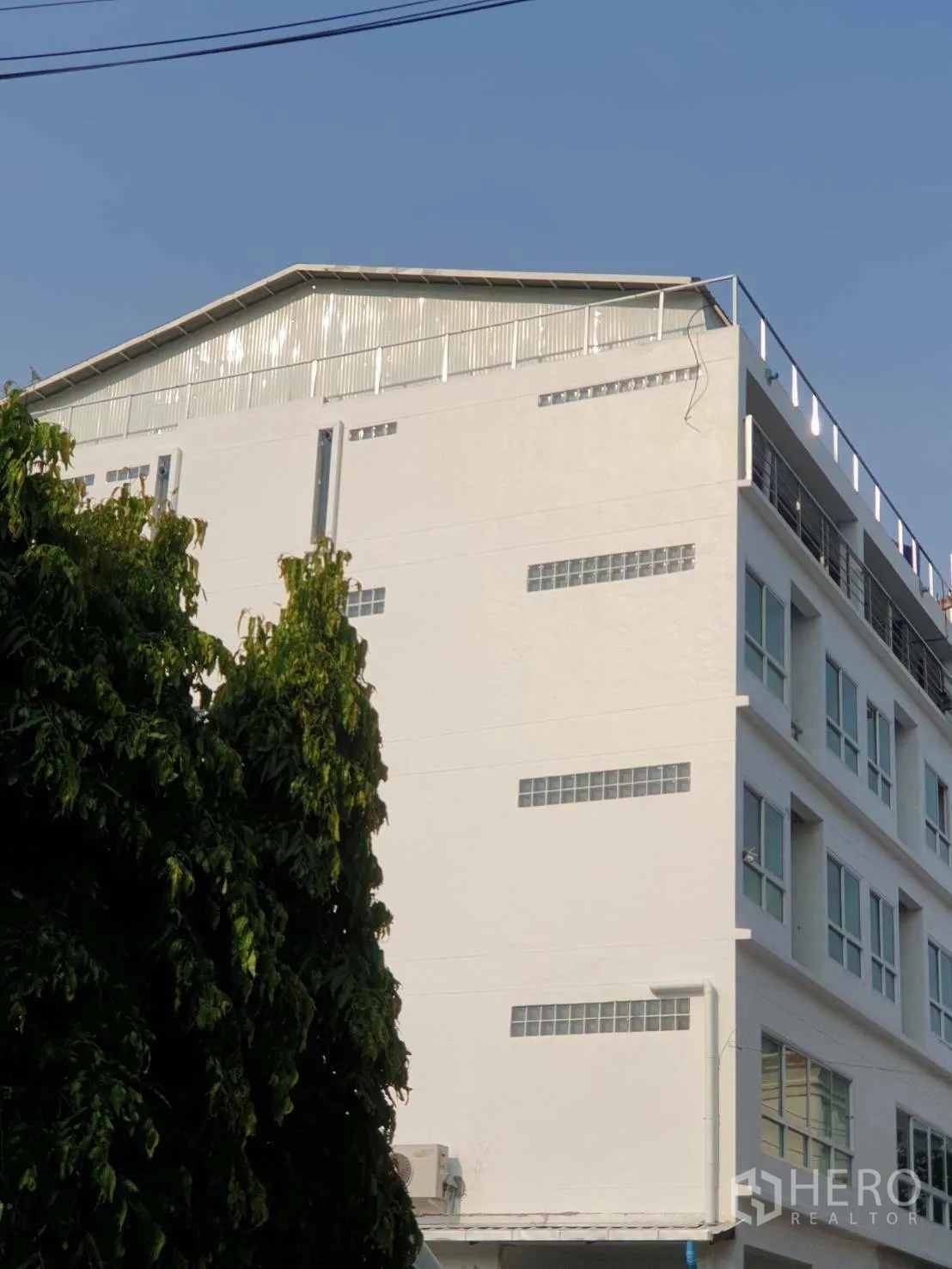 Office Space for rent or sale - Side view of the office block with glass-block windows and a rooftop structure.