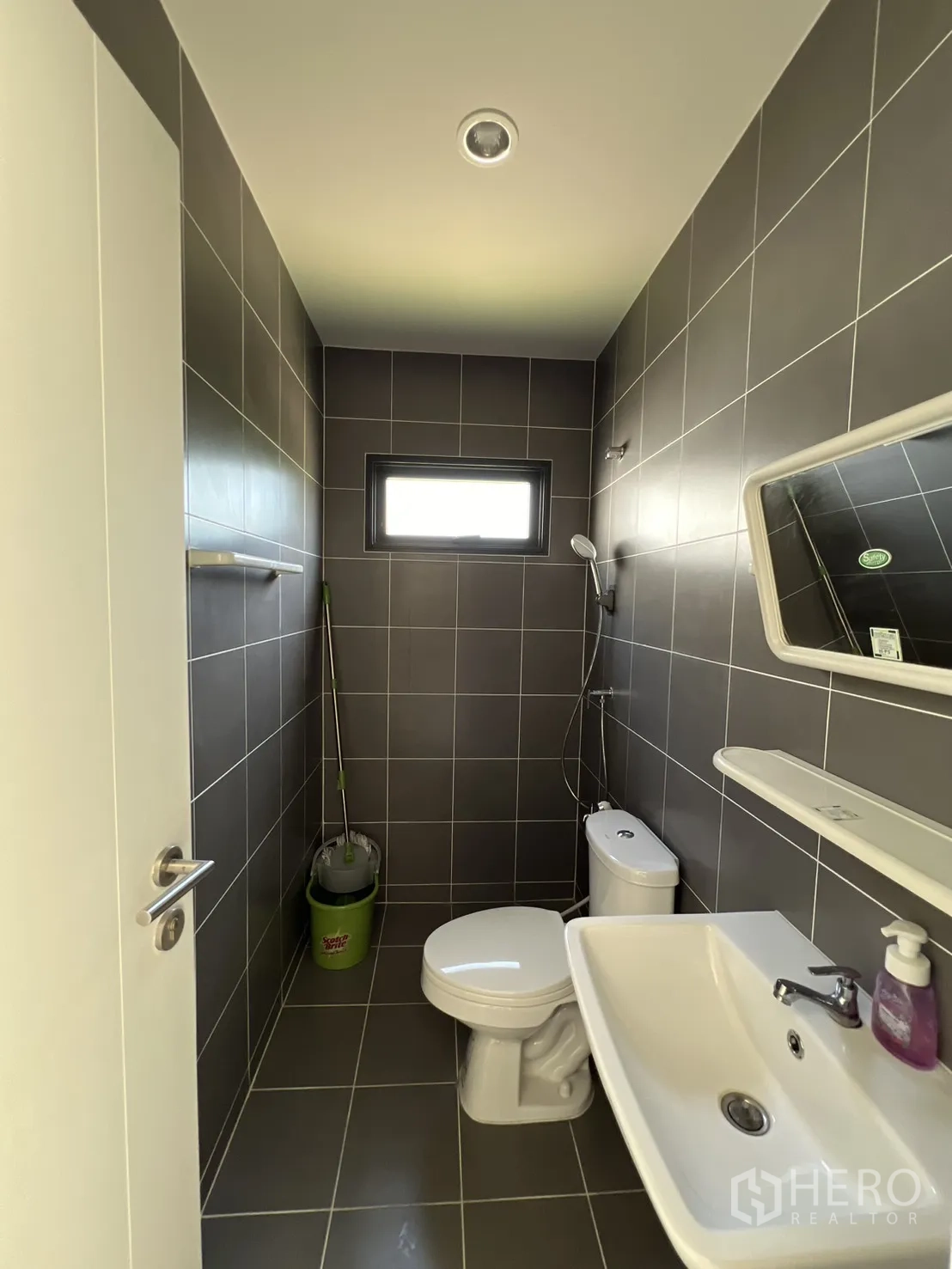 Detached House for rent or sale in Mueang Pathum Thani, Pathum Thani - Ground-floor bathroom with grey tiles, basin and toilet.