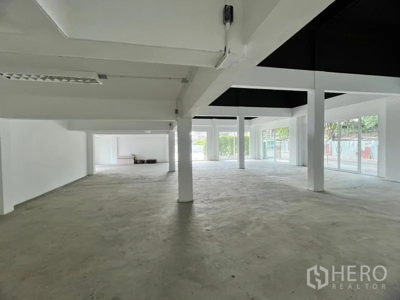 零售空间 出租在Huai Khwang, Bangkok - 开放式零售空间，白色立柱、混凝土地面与落地玻璃窗