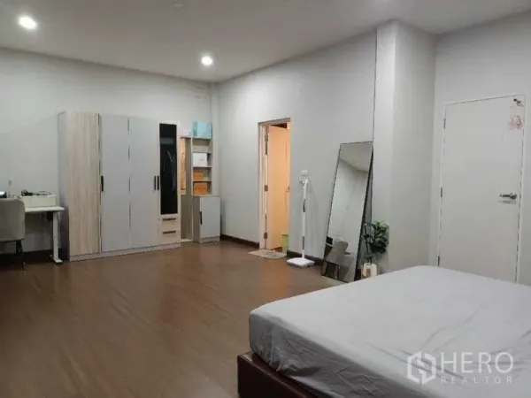 บ้าน ให้เช่าในMueang Nonthaburi, Nonthaburi - ห้องนอนกว้างพร้อมตู้เสื้อผ้า โต๊ะทำงาน และประตูห้องน้ำในตัว พื้นไม้