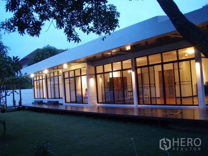 บ้าน ให้เช่าในHuai Khwang, Bangkok - ด้านนอกบ้านเดี่ยวหลังต่ำ พร้อมระเบียงไม้รอบบ้านและผนังกระจกขนาดใหญ่