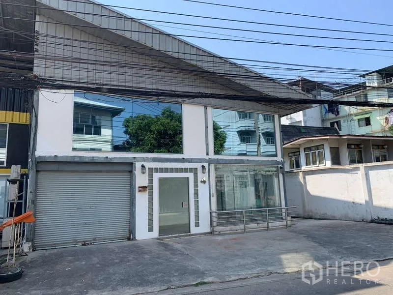 Warehouse for rent in Suan Luang, Bangkok - Street-facing warehouse with glass-fronted office and roller shutter in Suan Luang.