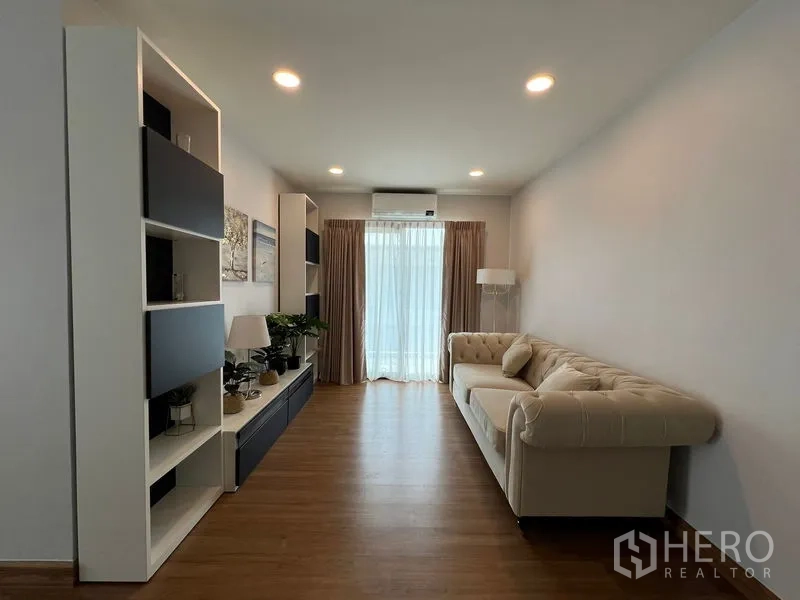 Detached House for rent in Bang Phli, Samut Prakan - Second-floor sitting area with shelving unit, tufted sofa and balcony door.