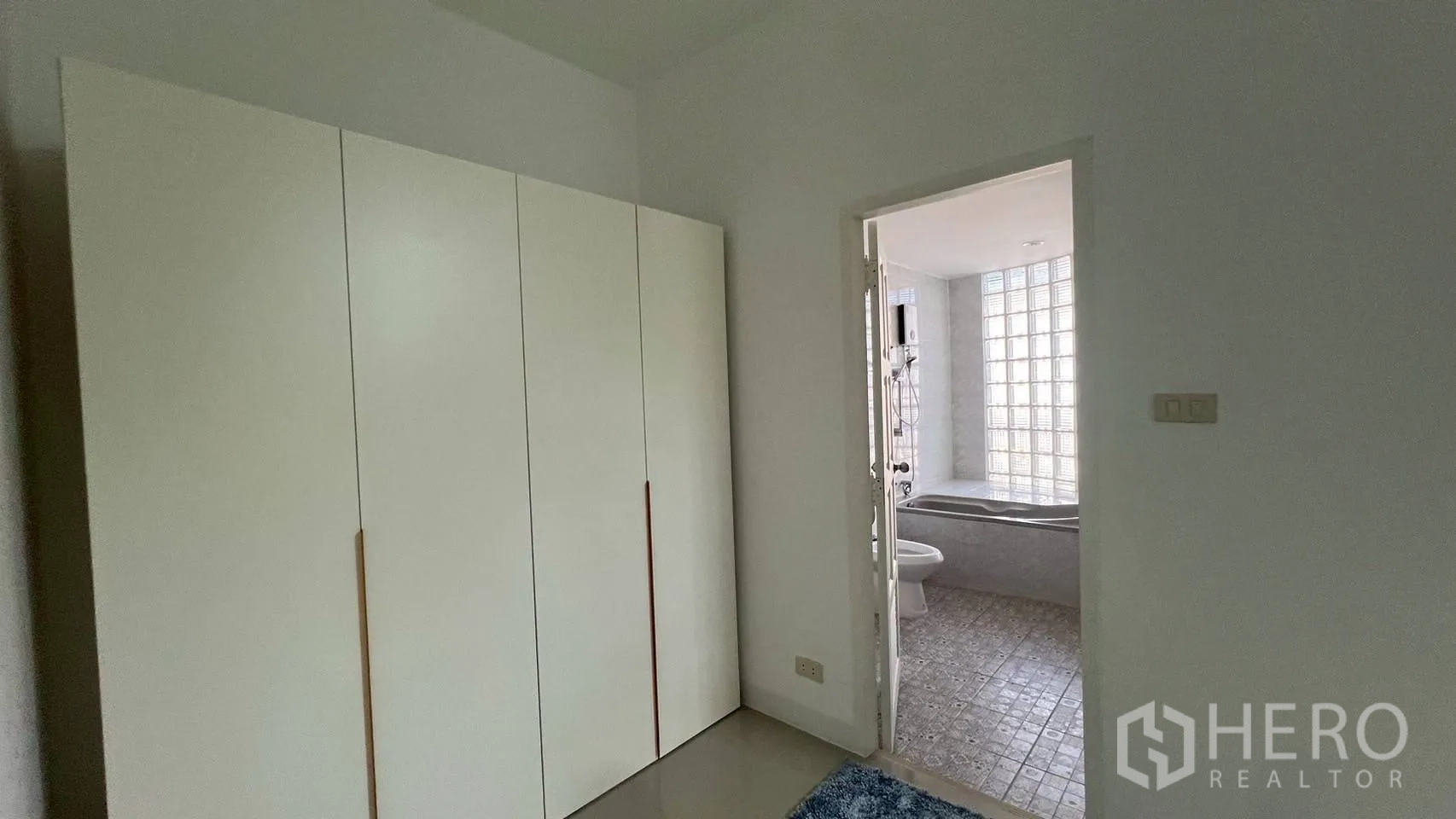 家庭办公室 for rent in Wang Thonglang, Bangkok - 小房间带高柜，通向带浴缸与玻璃砖墙的瓷砖浴室。