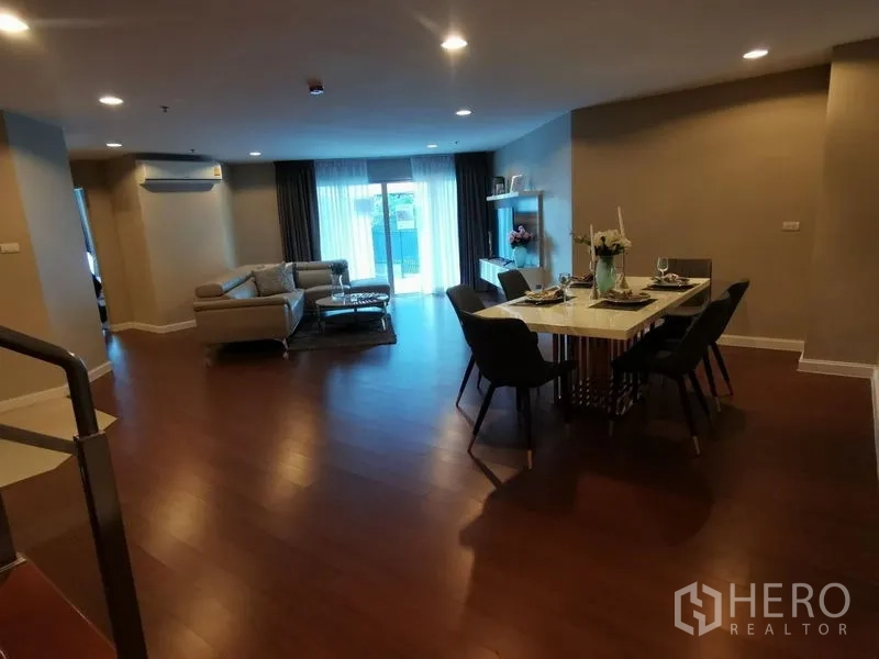 Condominium for rent or sale in Huai Khwang, Bangkok - Open-plan living and dining area with sliding doors to the terrace.