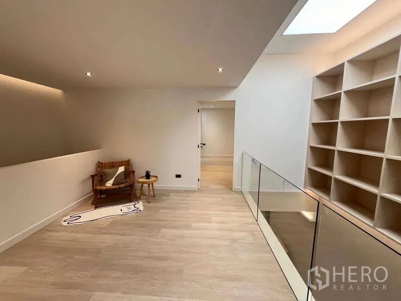 Townhouse for sale in Khlong Toei, Bangkok - Upper landing featuring glass railing, feature shelving and skylight lighting.