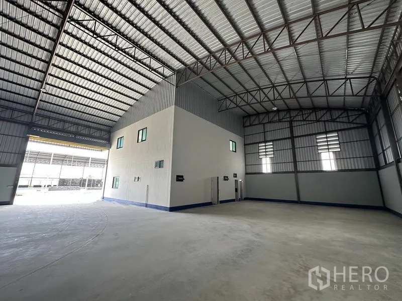 工厂 出租或出售在Sai Noi, Nonthaburi - 工业厂房一角，中央办公核心、通风百叶与宽装卸门。