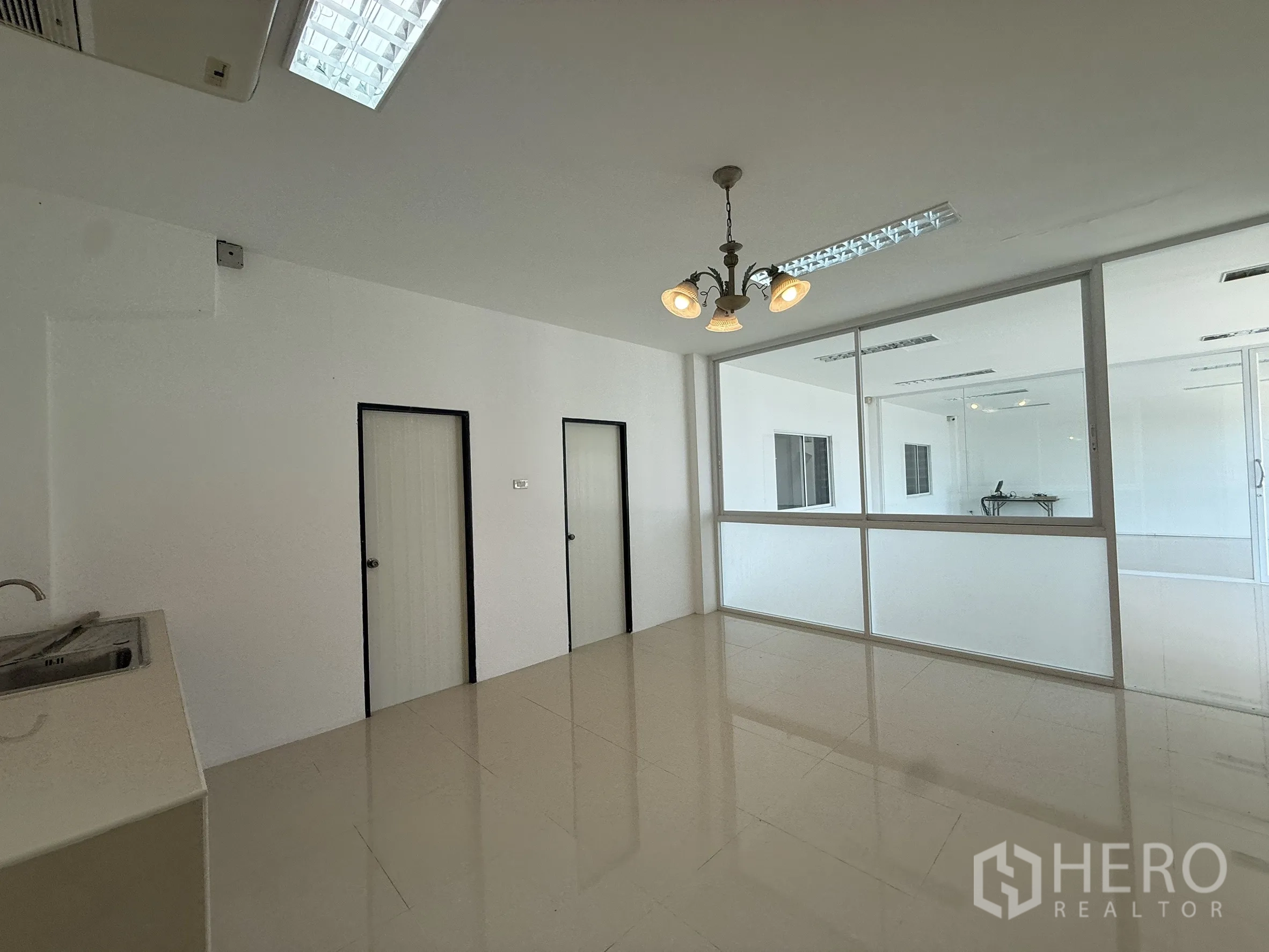 Warehouse for rent or sale in Bang Bo, Samut Prakan - Upper‑floor pantry or staff room with sink, chandelier and glass wall.