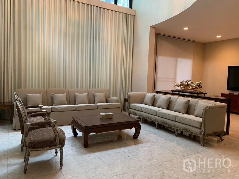 Detached House for rent or sale in Khan Na Yao, Bangkok - Formal living area with matching sofas, armchairs and a central coffee table.