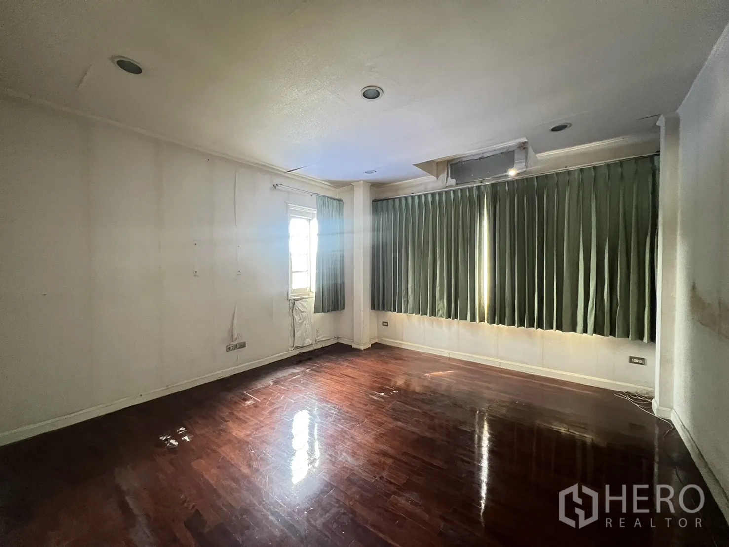 Detached House for sale in Saphan Sung, Bangkok - Bright room with dark wood floor, side window, and long green curtains.