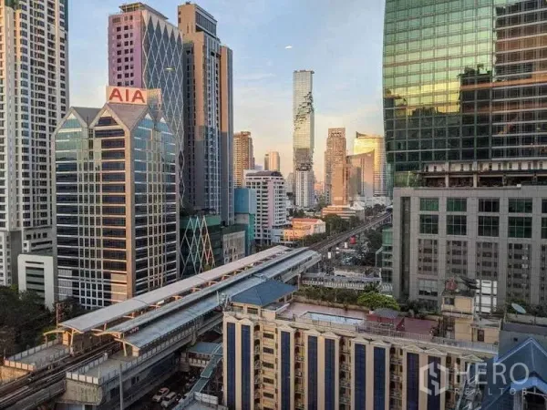 Condominium for rent in Sathon, Bangkok - Bangkok skyline with BTS station and elevated tracks among modern high-rises.