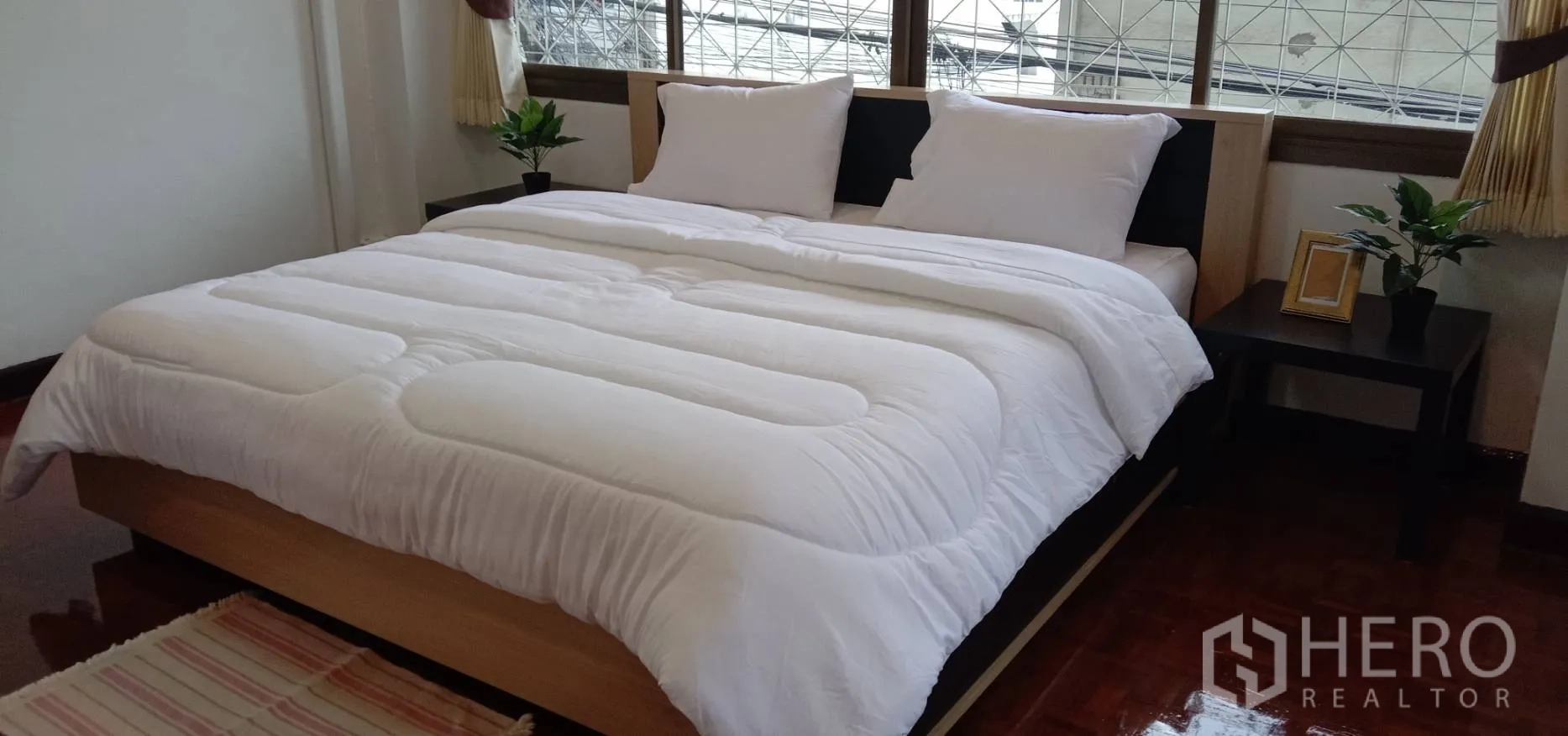 อพาร์ทเมนท์ ให้เช่าในRatchathewi, Bangkok - เตียงคิงส์ไซซ์พร้อมโต๊ะข้างเตียงและกระถางต้นไม้