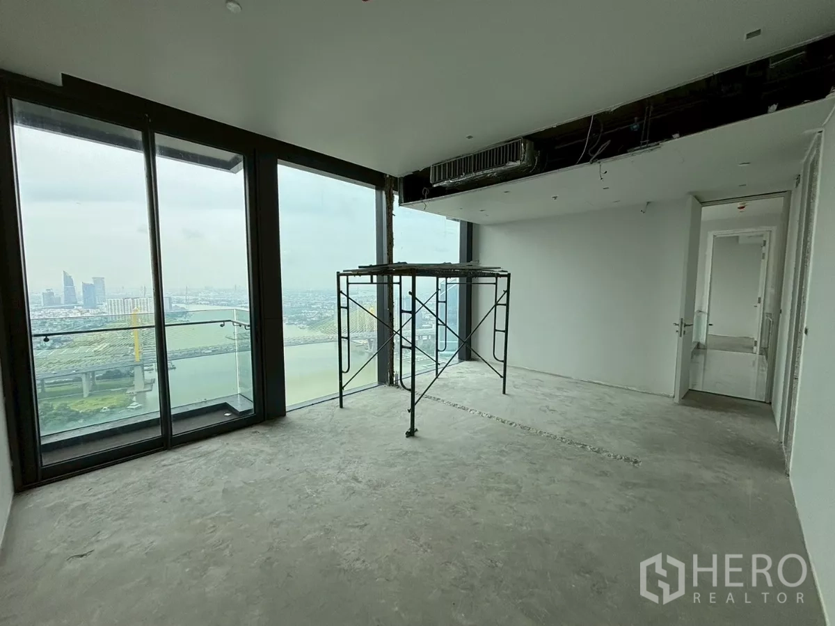 Condominium for sale in Bang Kho Laem, Bangkok - Spacious upper-floor room opening to a balcony with river and bridge vistas.