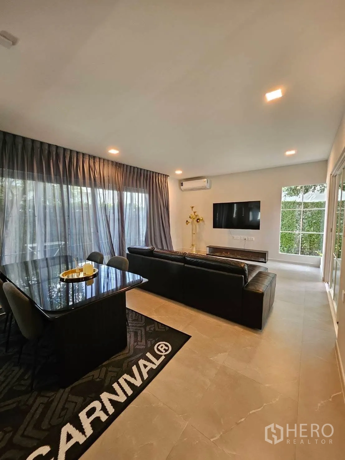 บ้านเดี่ยว for rent in Bang Phli, Samut Prakan - พื้นที่นั่งเล่นและทานอาหารแบบโอเพ่นแพลน โต๊ะรับประทานอาหารสีดำ โซฟา ทีวี และผ้าม่านขนาดใหญ่