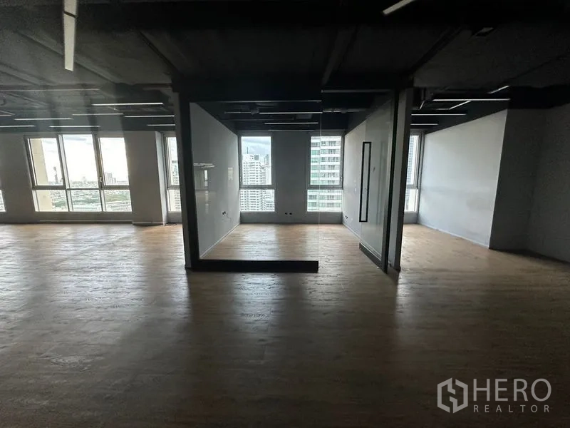 Office Space for rent in Bang Rak, Bangkok - Semi-partitioned workspace with city views and wood floors in a high-rise office.