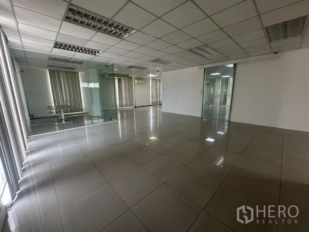 Office Space for rent in Huai Khwang, Bangkok - Wide corner workspace with floor-to-ceiling windows and a glass-box meeting room.