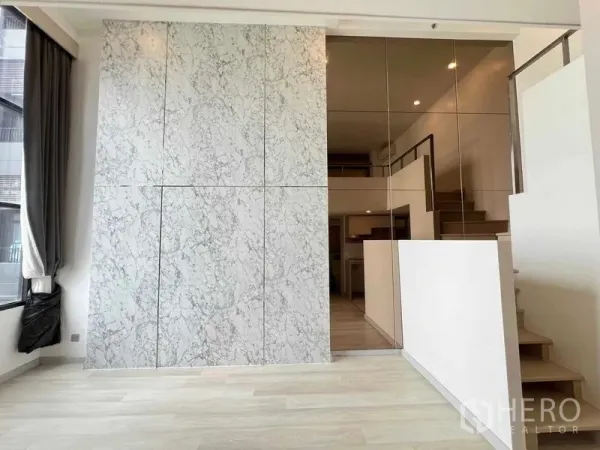 คอนโด ขายในSathon, Bangkok - ผนังหินอ่อนข้างผนังกระจกเงาและบันไดขึ้นชั้นลอย