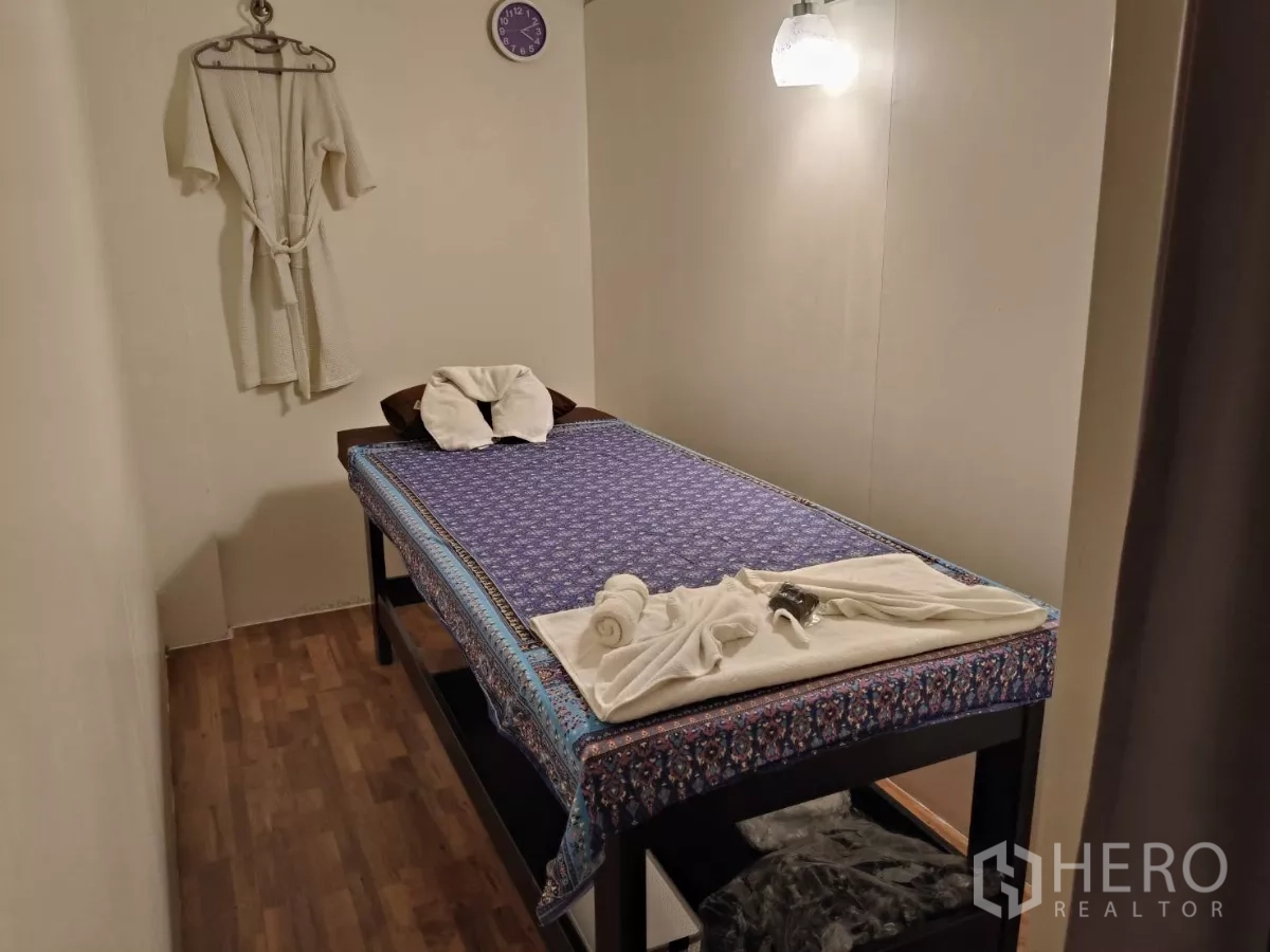 店屋 出租在Watthana, Bangkok - 私密理疗房，架高理疗床搭配浴袍与折叠毛巾。