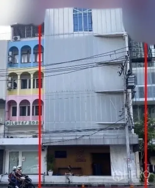 Shophouse for rent in Watthana, Bangkok - Multi-storey shophouse with grey facade in Thonglor beside a colorful building.