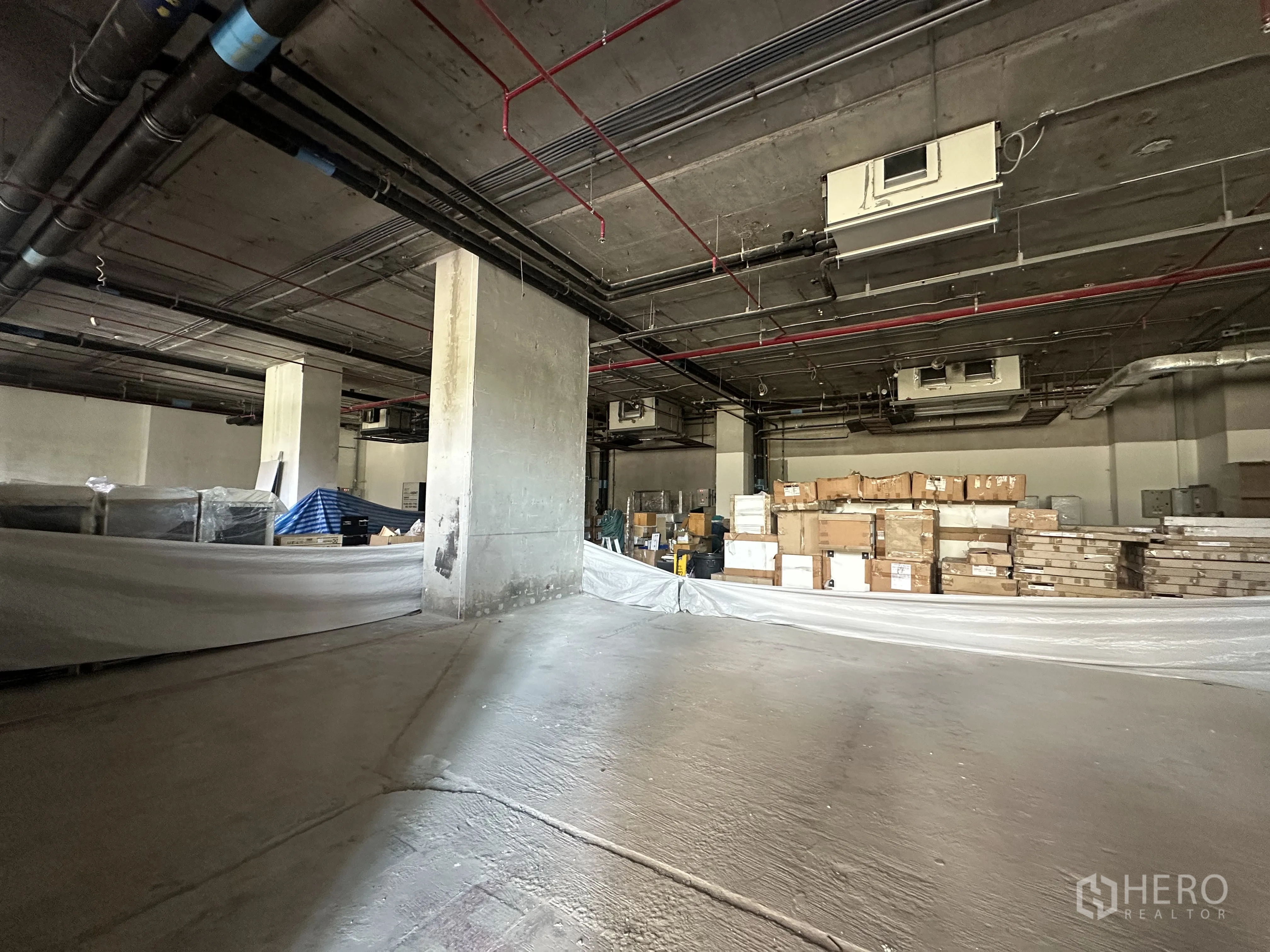 Retail Space for rent in Khlong Toei, Bangkok - Unfinished retail space showing exposed services and boxed materials for fit-out.